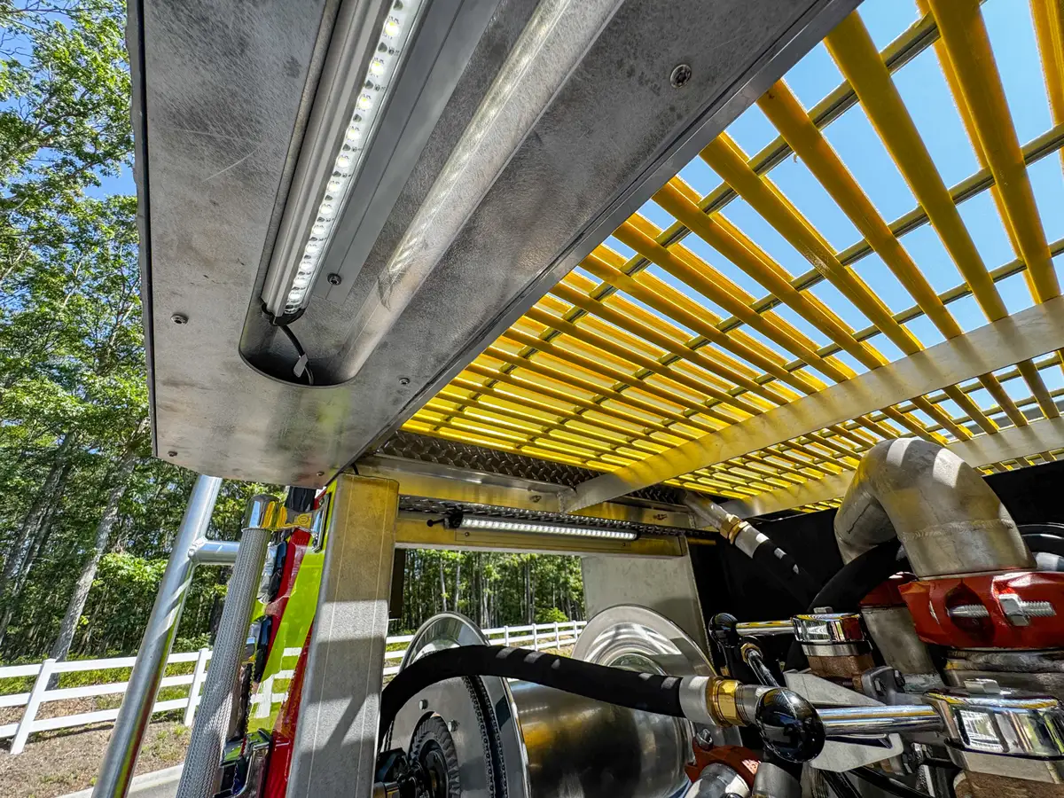 Under-grating view showing mounted components and side rail structure.